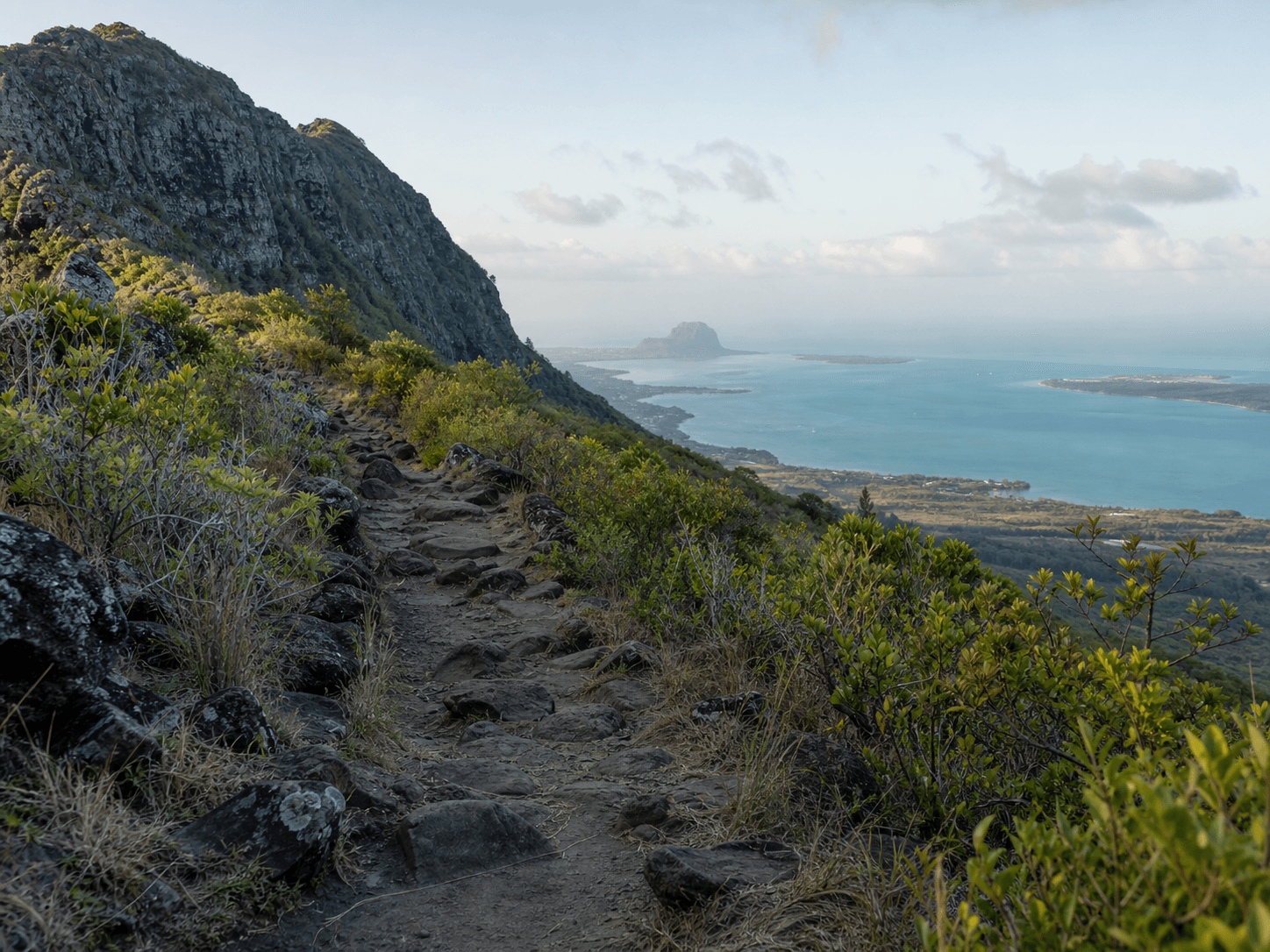 Illustrated mountain trail above a lagoon